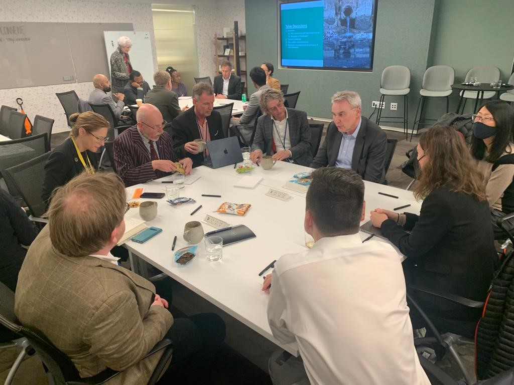 Eight people taking part in a discussion around a table at the World Water Week