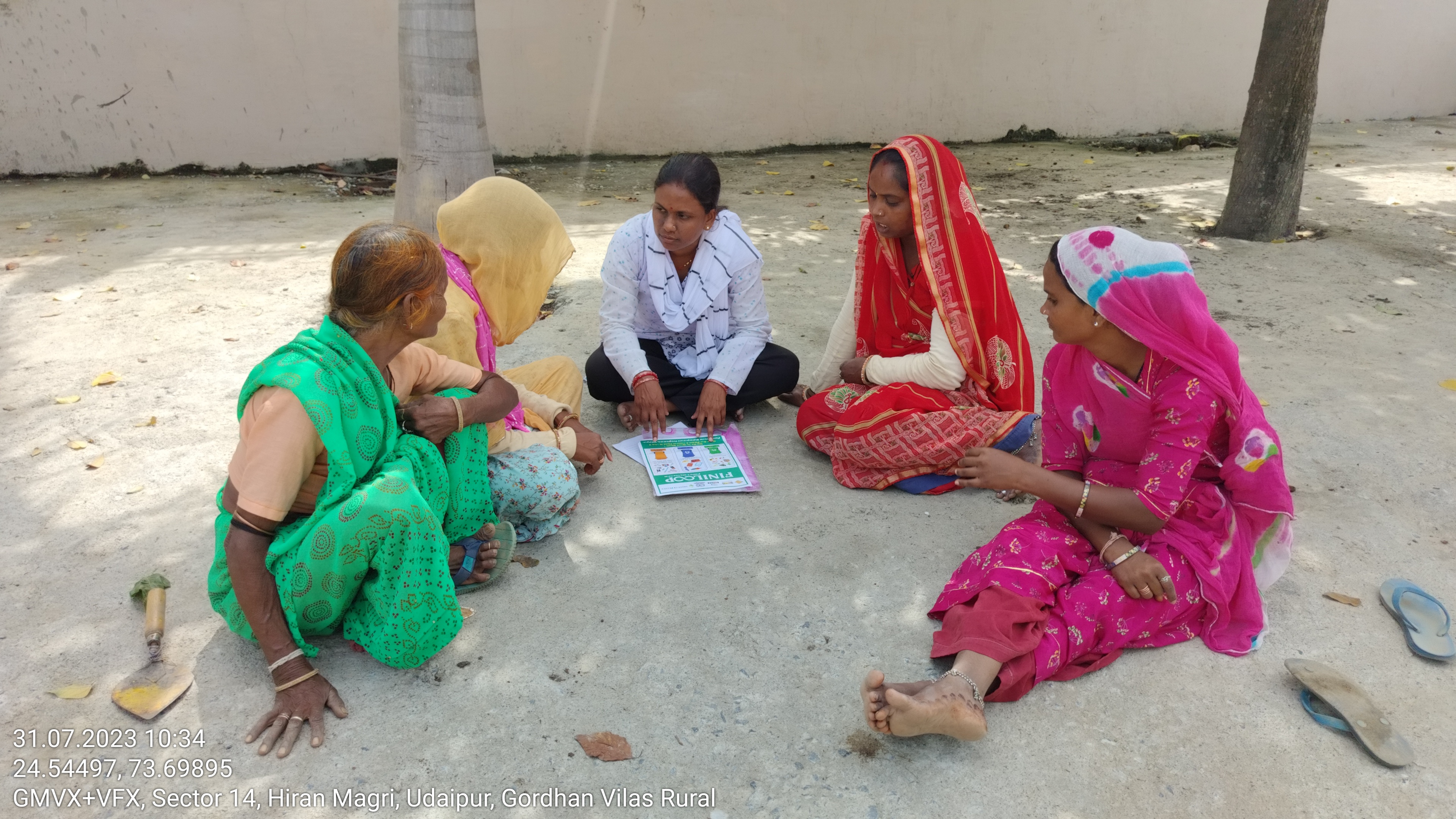 Awareness raising activity on segregation practices in Udaipur with five women sat around in a circle.