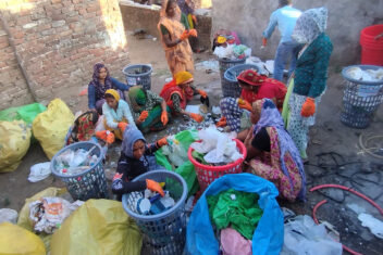 Group of women sorting plastic together on the floor
