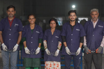 Five people stood in a line in FINILOOP uniforms holding safety googles