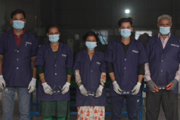 Five people in a line wearing PPE